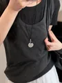 Primo piano di una collana etnica vintage con ciondolo geometrico argento su cordino nero. - Tondo Intrecciato (14#)