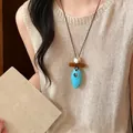 Collana etnica retrò con pendente in legno e ovale turchese su top in maglia beige. - Ovale Geometrico (26#)
