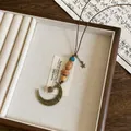 Dettaglio di collana etnica vintage con perle di legno e pendente a mezzaluna in ottone - Luna e Stelle (31#)