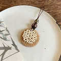 Primo piano di una collana con ciondolo in legno retrò folk con paglia intrecciata e perline - Disco Intrecciato (35#)