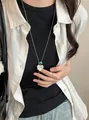 Collana retrò con ciondolo a cuore argento e perla blu su catena lunga indossata - Piastrina Cuore Argento (51#)