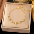 Elegante pulsera de flor de camelia en acero de titanio chapado en oro 18k con cristales - Flor de Cuatro Pétalos de Estrás (E2524) / Dorado