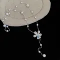 Nahaufnahme einer eleganten Perlenhalskette mit schillerndem Blumenanhänger - 16# Halskette Irisierender Blumenanhänger