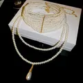 Elegante mehrlagige weiße Perlenkette mit goldenem Tropfenanhänger auf Geschenkbox - 52# Halskette Französischer Mehrlagiger Tropfen