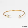Elegante vergulde roestvrijstalen manchetarmband met fonkelende zirkonia vlinders - Armband (A1344) / Goud