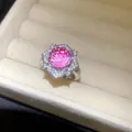 Detaillierte Nahaufnahme eines schimmernden rosa Zirkon-Blumenrings in einer Schmuckschatulle - Blumenstil / Silber-Rosa