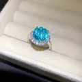 Eleganter silberfarbener offener Ring mit großem funkelndem blauem Zirkonia und Halo-Steinen - Blumenstil / Silber-Seeblau