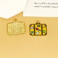 Detail of suitcase-shaped enamel charm with travel-themed prints for DIY jewelry making - Yellow