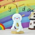 Close-up detail of a cute light blue plush jellyfish keychain hung on a wooden stand - Octopus Shape / Blue / Height 14cm