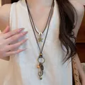 Detail view of a Bohemian double-layered necklace with star and music note pendants. - Musical Note Star Style (46#) / Brown/Gold