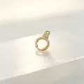 Detailed macro view of a premium golden stainless steel handcuff-shaped accessory link - Gold