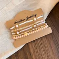 Détail en gros plan d'un ensemble de bracelets en perles bohèmes sur carte Kraft - Ensemble de 5 Bracelets Bohémiens / Blanc et Café