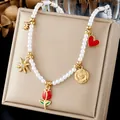 Detail of pearl necklace with red rose and sun charms on a luxury beige display stand - Vintage Rose Cameo Heart Five Charm Artificial Pearl Necklace (N4582)