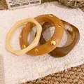 Detailansicht eines dreiteiligen Sets unregelmäßiger Armreifen aus Harz und Holzoptik - Dreiteiliges Set / Kaffee-Khaki-Beige