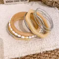Nahaufnahme eines Sets aus unregelmäßigen Harz-, Holz- und Perlenarmbändern im Boho-Stil. - 7-teiliges Set / Silber-Khaki