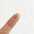 Detailaufnahme einer 18k vergoldeten Edelstahlperle auf der Fingerspitze zum Vergleich. - Sonnenblumen-Zahnrad-Stil (3#)