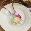 Detaillierte Makroansicht der bunten Bast-Halskette mit hängenden weißen Kaurimuscheln - Halbkreis gewebter Muschel-Stil (41#) / bunt