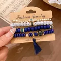 Close-up of four-piece ethnic stretch bracelet set with hamsa charm and tassel - Bracelet Style / Four-Piece Set / Dark Blue
