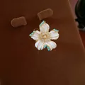 Gros plan détaillé d'un bijou fleur en émail blanc orné de zircons brillants et perles bleues - Bague Fleur