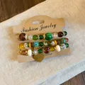 Close-up detail of bohemian multi-layer beaded bracelet set with heart charm - Style 1 / 3 Pieces Pack / Gold-Yellow-Green