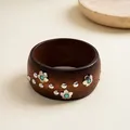 Detailed view of a retro wooden bangle with silver flower studs and turquoise accents - Dark Coffee