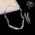 Detail van een elegante zilverkleurige sieradenset met glinsterende zirkonia kwastjes. - Ketting En Oorbellen (52#) / Goud