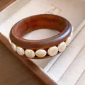 Detailaufnahme eines Vintage-Holzarmreifs mit Inlays aus weißen Acryl-Perlen. - Breiter Vintage Stil / Kaffee Mit Weißer Scheibendekoration