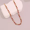 Gold-toned four-leaf clover necklace with red and pink crystals on white stone prop - Red Series (3#)