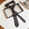Vista detallada de una elegante corbata a rayas blancas y negras en fondo minimalista - Estilo de Rayas / Negro