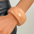 Detailed close-up showing the marbled texture of a peach resin chunky bangle on wrist - Round (4287) / 30mm / Light Pink