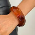 Close-up detail of a vintage amber marbled resin faceted wide bangle on a model's wrist - Rhombus (WG-0190) / Coffee