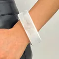 Detailed close-up of a vintage white marbled resin wide bangle worn on the wrist - Square (4734) / Clear