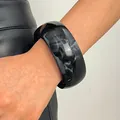 Close-up of black resin wide bangle with white marble ink-wash patterns on model's wrist. - Round (WG-0891) / 30mm / Black