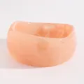 Macro view of vintage marbled acrylic wide bangle with unique wavy edge design in peach - Irregular Height (3599) / Light Pink
