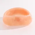 Close-up of a vintage orange marbled resin wide bangle with smooth polished finish - Twisted (N-013) / Light Pink