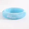 Close-up of a wide light blue resin bangle with white marble textures and glossy finish. - Arc Style (7221) / 21mm / Blue
