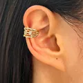 Close-up of a multi-layer gold ear cuff with zircon inlays on a woman's ear. - Multi-layer Gold Ear Cuff (3886) / Gold
