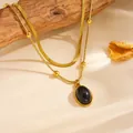 Dettaglio ravvicinato di una collana d'oro a doppio strato con ciondolo ovale in pietra nera - Catena a Doppio Strato Pendente Ovale (C418) / Collana Ovale Nero Oro