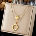 Detailed macro shot of gold double layer necklace with heart and irregular ring pendants - Gold Heart Irregular Wave Circle Layered Chain (N4576)