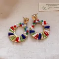 Detailansicht handgefertigter Bali-Ohrringe mit leuchtenden bunten Kristallen - Goldbasis / bunt