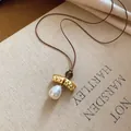 Elegant vintage gold-tone geometric pendant necklace featuring a white pearl drop on brown cord - Geometric Metal Bead Style (37#) / Gold/White/Coffee