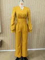 Dettaglio frontale di una tuta a maniche lunghe giallo senape con scollo a V su un manichino - XS / Set / Giallo