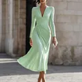 Elegant mint green V-neck long sleeve ruched midi dress worn by a model in a city setting. - XS / Dresses / Light Green