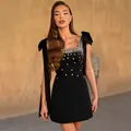 Détail d'une robe bandage noire élégante avec strass et bretelles à nœuds de fête - S / Robes / Noir