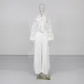 Detailansicht der weißen Spitzenbluse mit Schleife und der passenden weiten Hose - S / Oberteil Und Unterteil / Weiß