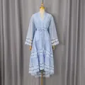 Vue de face d'une robe bleu clair brodée de dentelle avec ourlet à volants et lien - S / Robes / Bleu