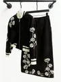 Detalle del conjunto de dos piezas de ante negro con bordados de rosas blancas. - M / Top Y Pantalón / Marrón