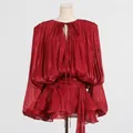 Close-up of red pleated mini dress with ruffles and tie-neck detail on a mannequin - S / Dresses / Red