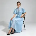 Modella con un abito midi azzurro in stile francese con fiori applicati e maniche a sbuffo - Taglia S / Vestiti / Blu