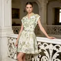 Full-length view of an elegant tropical palm print shirt dress shown in a classical balcony setting - S / Dresses / Green